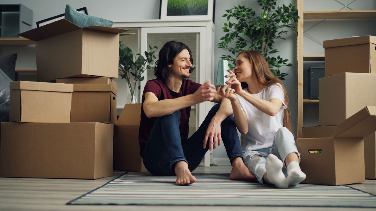 Buy a house with student loans – smiling young couple on moving day in their new home