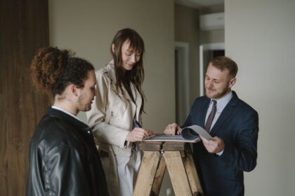Closing costs – couple signing home purchase documents with an agent