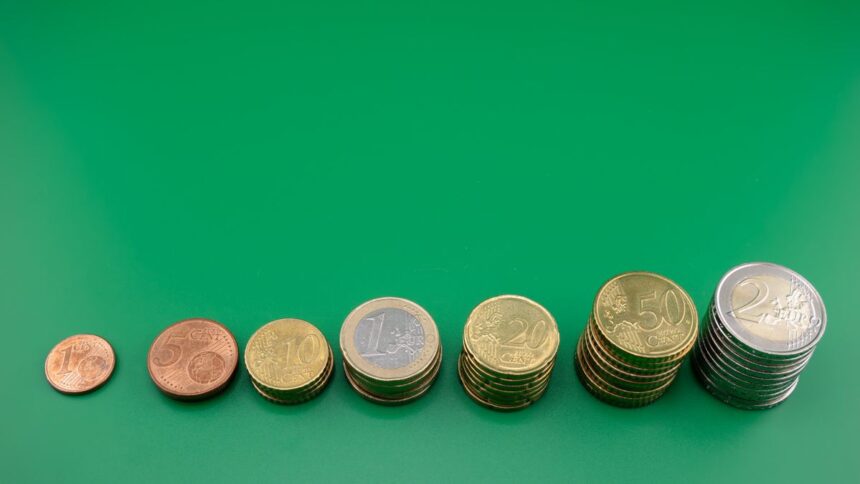 Compound interest – coins stacked in growing piles showing compounding growth