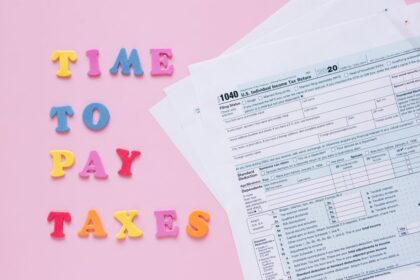 File taxes for the first time – 1040 tax forms with colorful Time to Pay Taxes letters