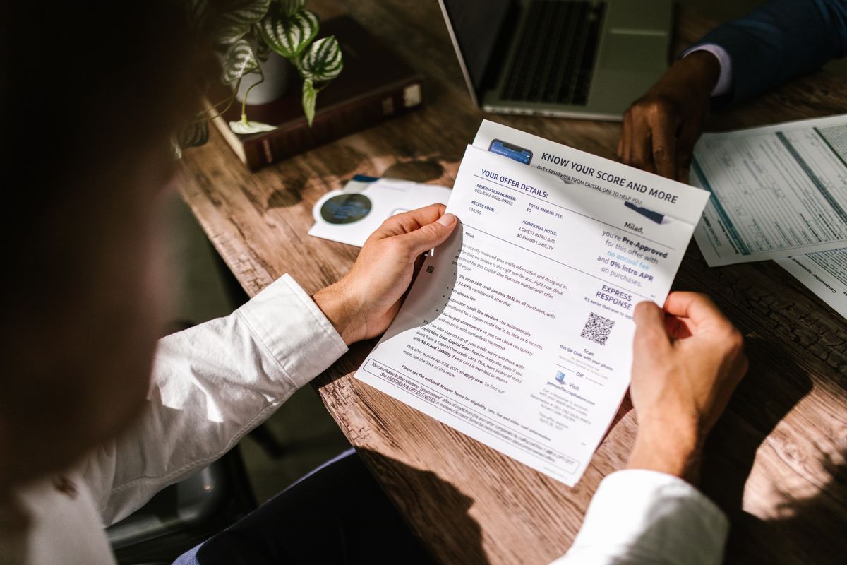 Fix bad credit – man reviewing a financial document at his desk