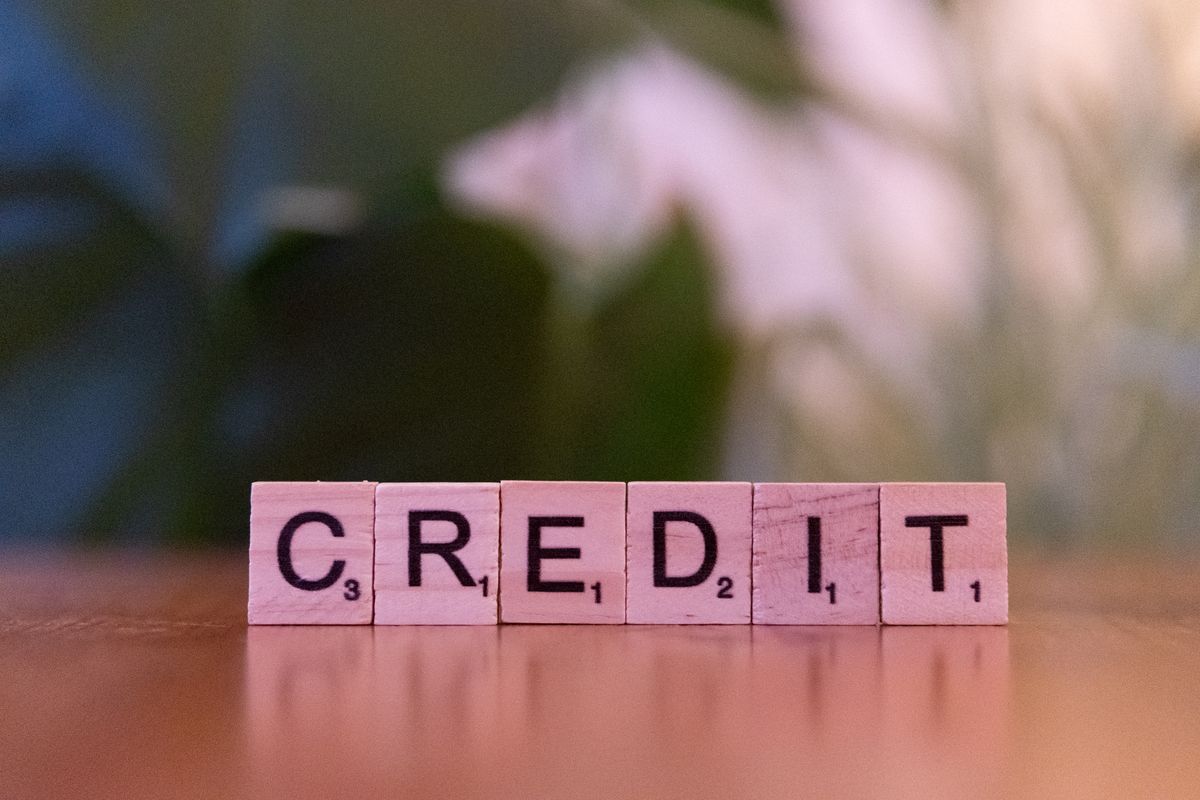 Good credit score – wooden blocks spelling credit against a blurred leafy background