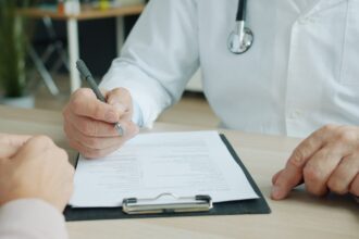 How health insurance works – doctor and patient reviewing medical documents