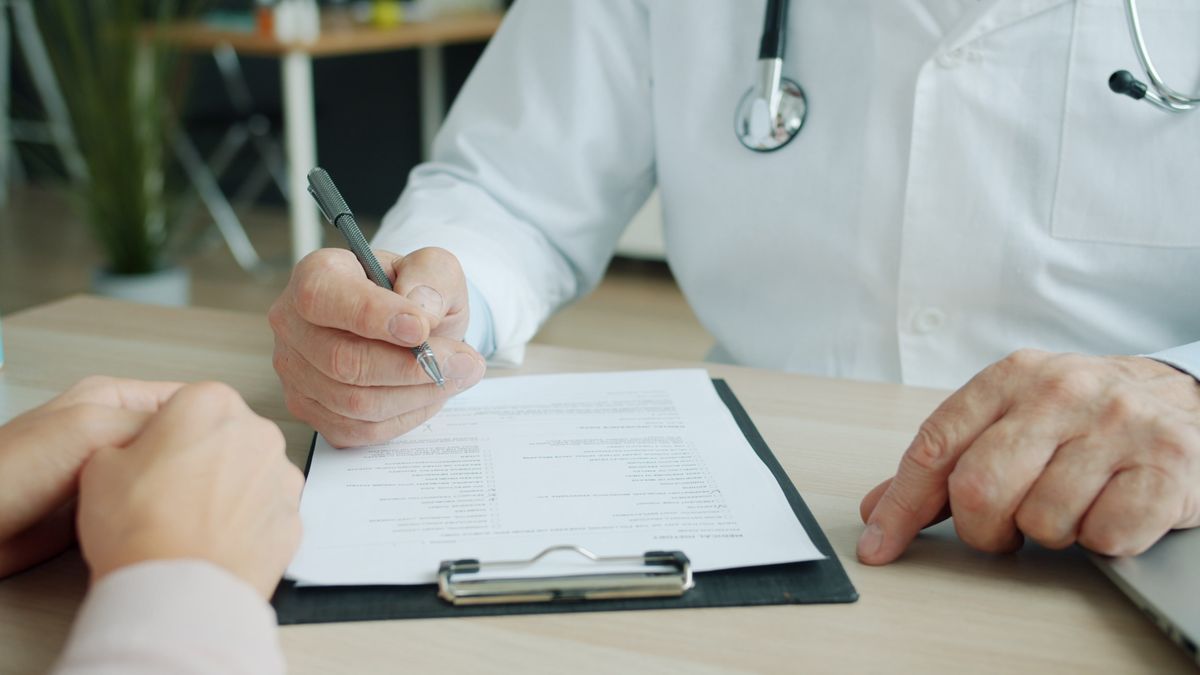 How health insurance works – doctor and patient reviewing medical documents