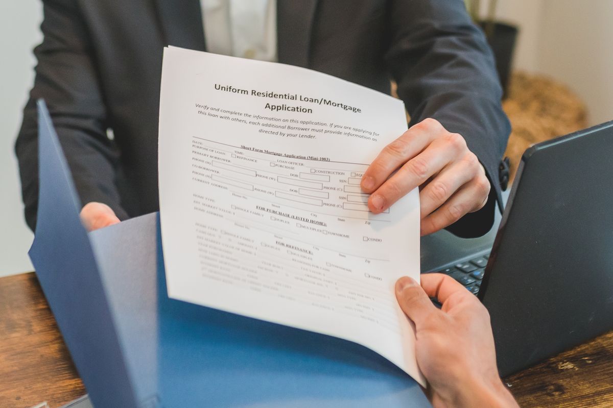 Mortgage pre-approval – hands exchanging a mortgage application form