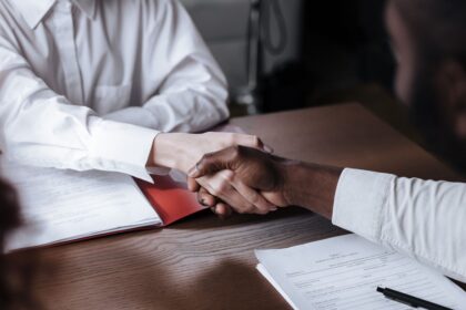 Negotiate your first salary – business handshake over documents after an agreement