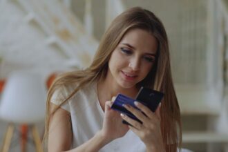 Open a bank account – young woman using a banking app and card at home