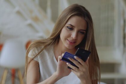 Open a bank account – young woman using a banking app and card at home