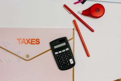 Quarterly estimated taxes – calculator, pens and a folder labeled Taxes