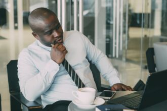 Register a business name in Nigeria – businessman working on a laptop at his desk