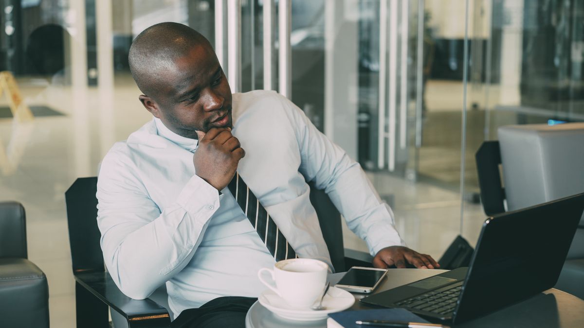 Register a business name in Nigeria – businessman working on a laptop at his desk
