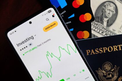Robo-advisor – smartphone showing an investing app beside cards and cash