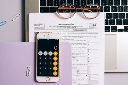 Self Assessment tax return – tax documents, a calculator app and a laptop for self-employed accounts