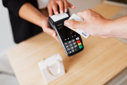 Use a credit card – hands paying with a credit card on a contactless terminal